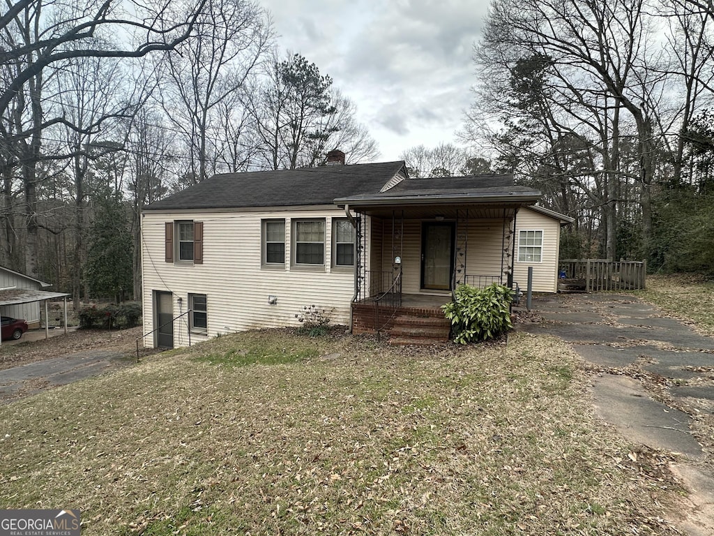 view of front of home with a porch, a chimney, and aphalt driveway