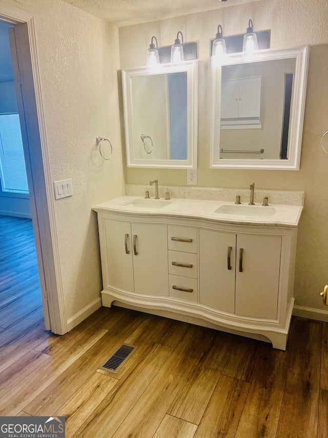 full bathroom featuring wood-type flooring, visible vents, and a sink