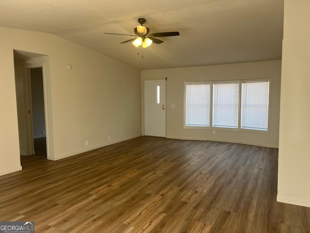 unfurnished living room with lofted ceiling, wood finished floors, a ceiling fan, and baseboards