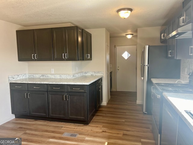 kitchen with visible vents, range, light countertops, a textured ceiling, and light wood-style floors