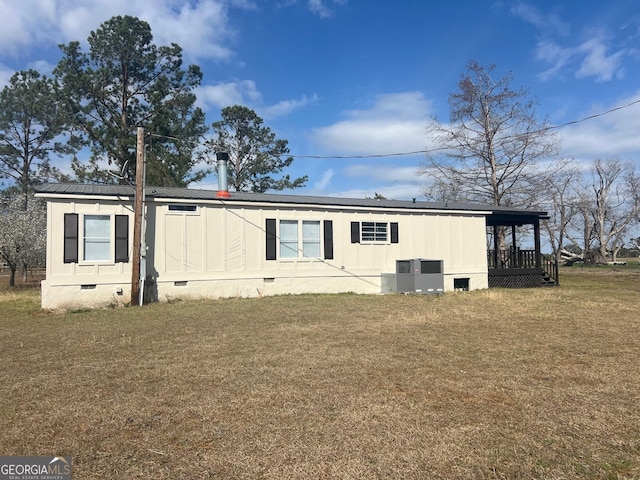 exterior space featuring a lawn, crawl space, roof mounted solar panels, metal roof, and cooling unit