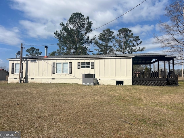 rear view of house with metal roof, crawl space, a deck, a yard, and central AC