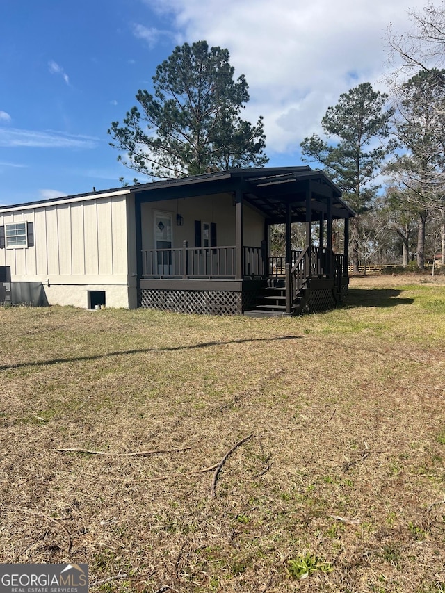 view of side of property featuring covered porch and a yard