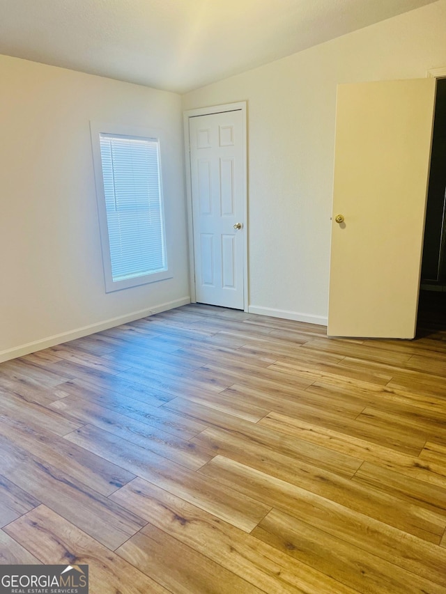 unfurnished room with light wood-style flooring and baseboards