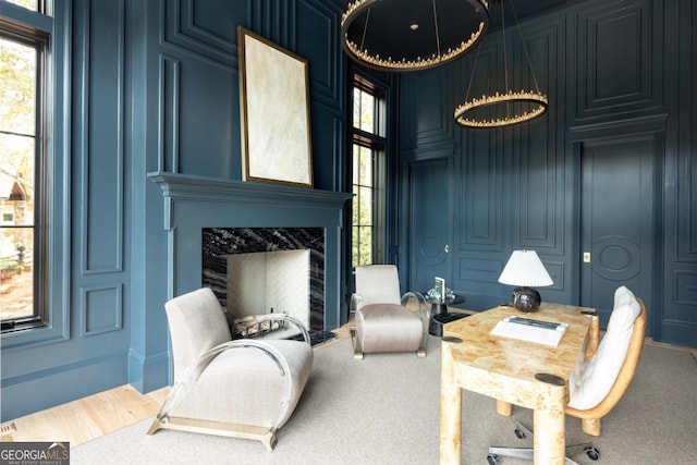 sitting room with carpet floors, a fireplace, and a decorative wall