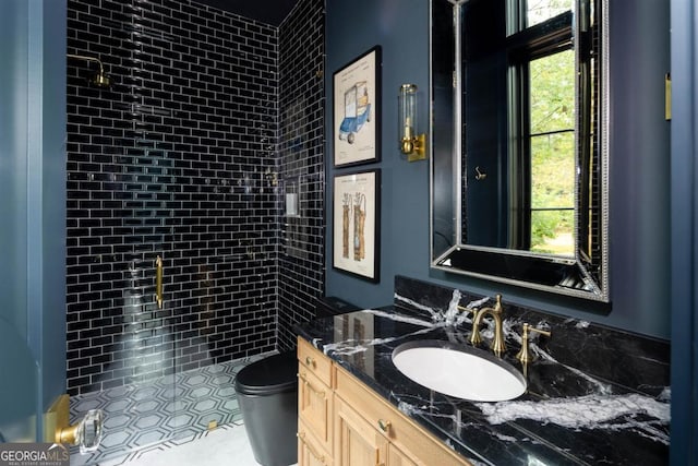 bathroom with a stall shower, vanity, and toilet