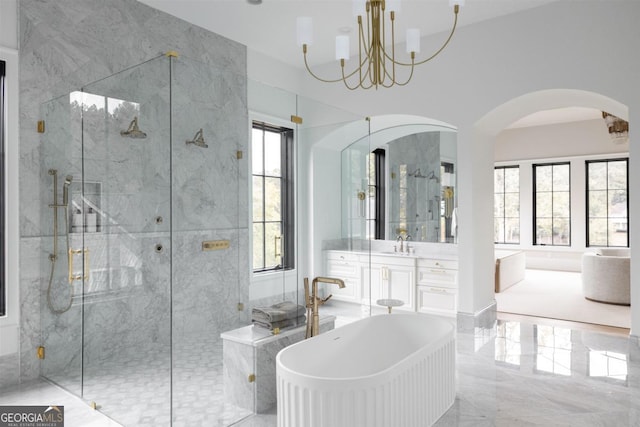 full bath with a chandelier, vanity, marble finish floor, a soaking tub, and a stall shower