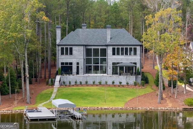 rear view of property featuring a view of trees, a lawn, a chimney, a water view, and stairs