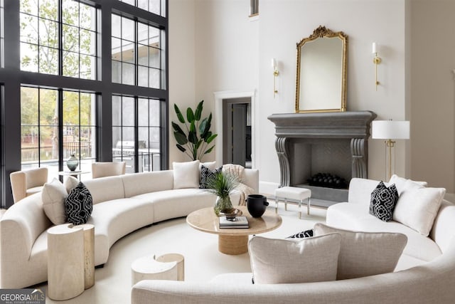 living room featuring a towering ceiling and a fireplace