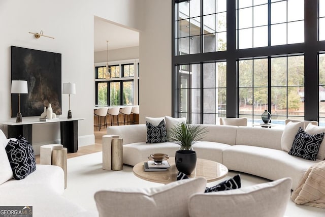 living area with a towering ceiling and wood finished floors