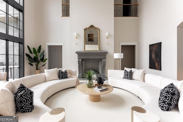 living room featuring a towering ceiling and a fireplace