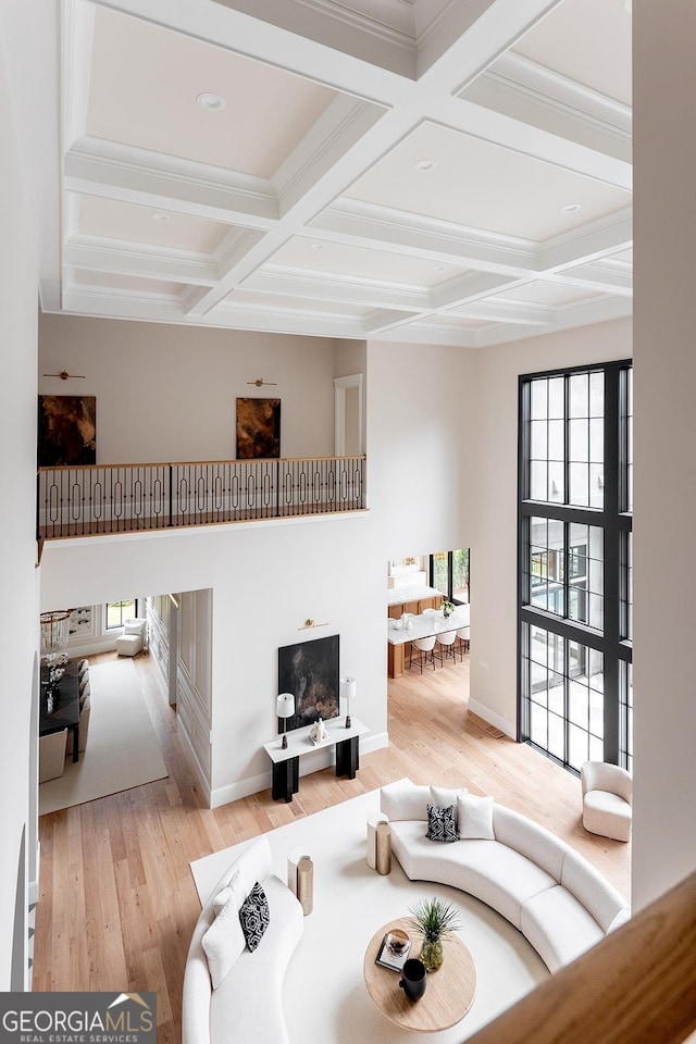 sunken living room with beam ceiling, coffered ceiling, baseboards, and wood finished floors