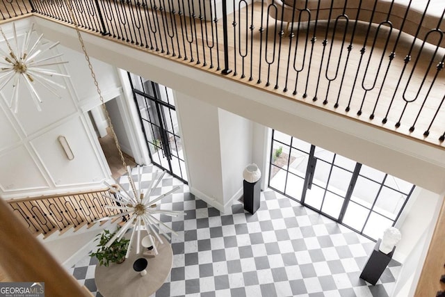 interior space featuring a notable chandelier, a towering ceiling, and baseboards