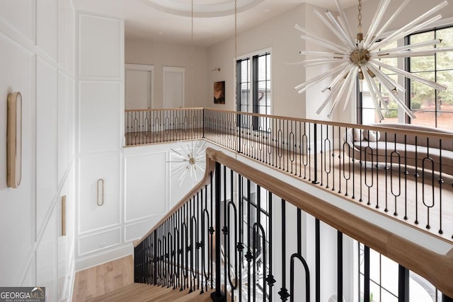 stairway featuring a chandelier and wood finished floors