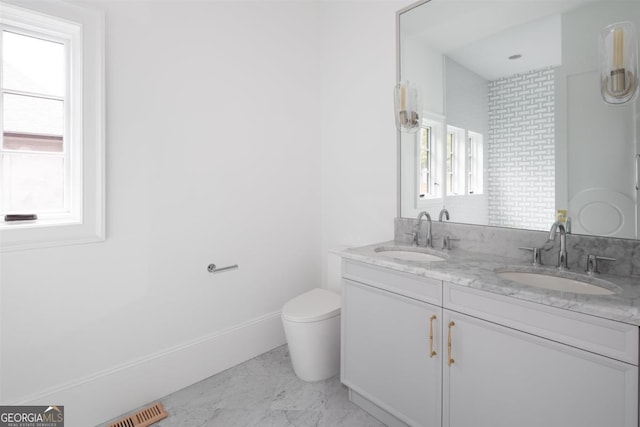 bathroom with a wealth of natural light, marble finish floor, and a sink