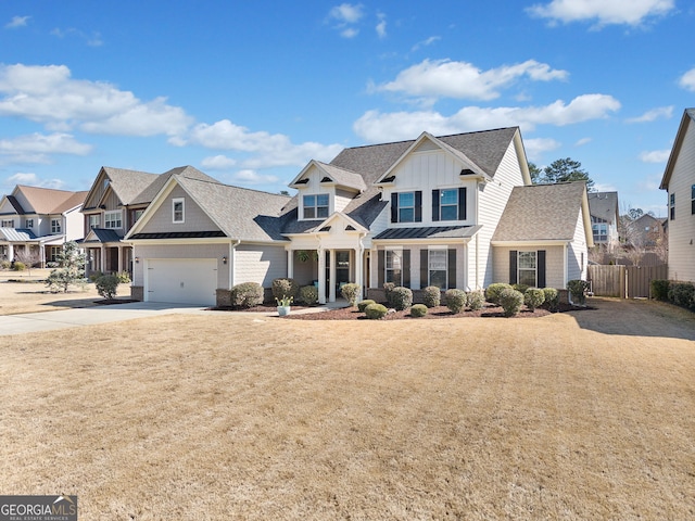 view of front of house with fence, driveway, a standing seam roof, a residential view, and board and batten siding