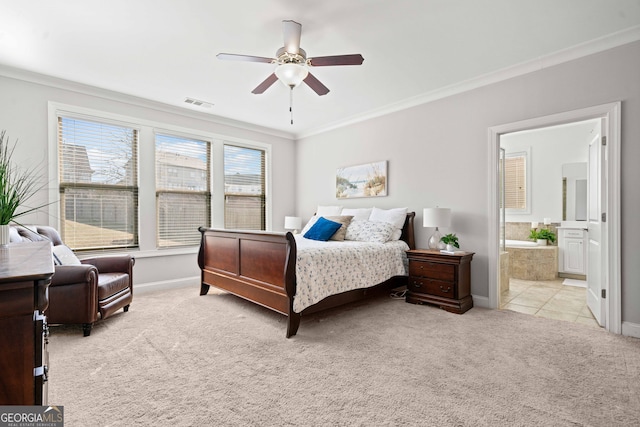 bedroom featuring baseboards, visible vents, ornamental molding, ensuite bathroom, and light colored carpet