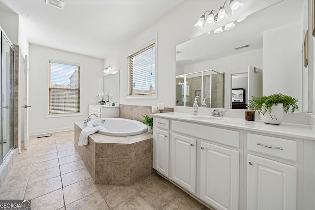 bathroom with a wealth of natural light, visible vents, a stall shower, and a bath