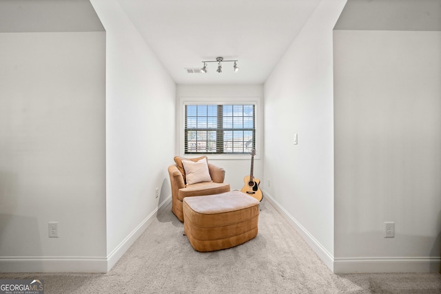 sitting room featuring track lighting, carpet flooring, and baseboards