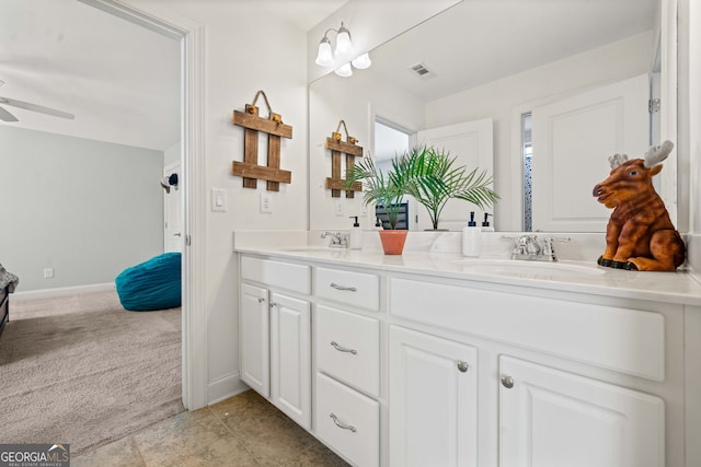 bathroom featuring ceiling fan, double vanity, visible vents, and a sink