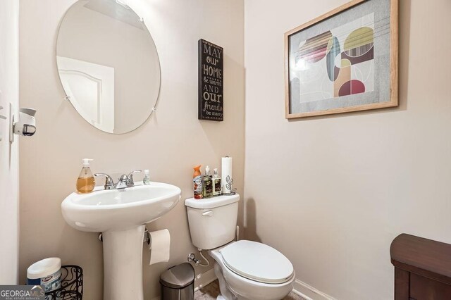 bathroom with baseboards and toilet