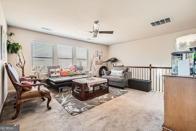 living room with a ceiling fan, visible vents, and carpet flooring