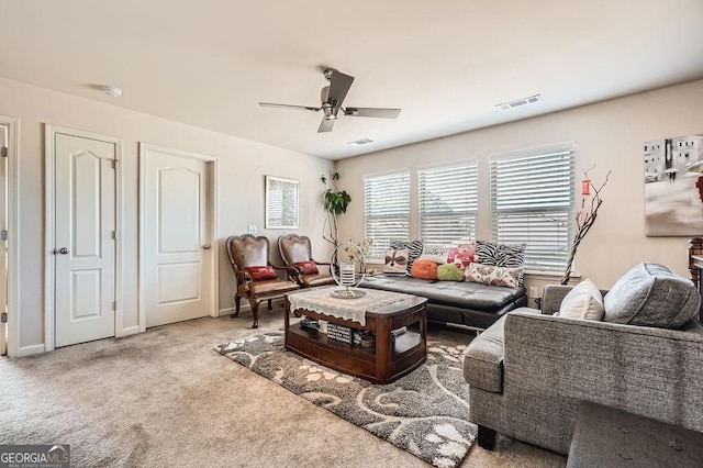 carpeted living room with baseboards, visible vents, and a ceiling fan