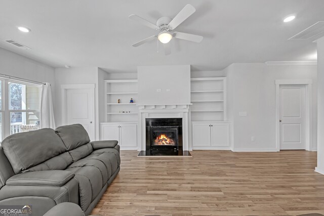 living room with light wood finished floors, a fireplace with flush hearth, a ceiling fan, and recessed lighting