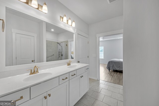 bathroom with a stall shower, tile patterned flooring, a sink, and double vanity