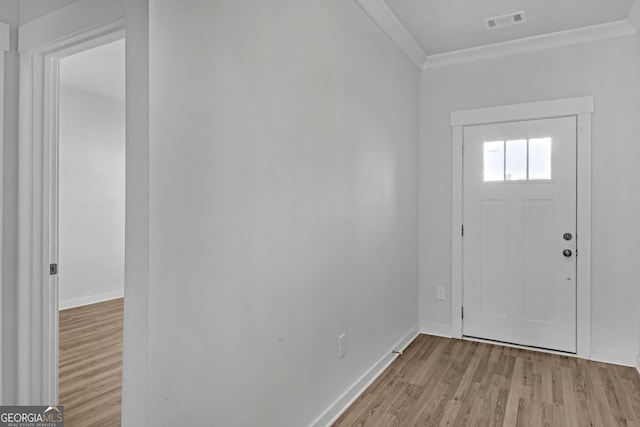 entrance foyer featuring ornamental molding, light wood-type flooring, visible vents, and baseboards