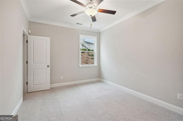 empty room with ceiling fan, visible vents, baseboards, ornamental molding, and carpet