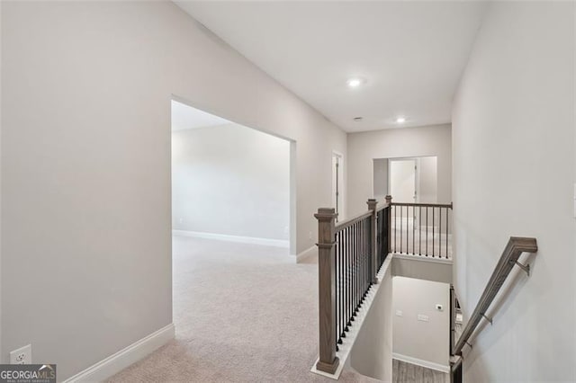 corridor featuring recessed lighting, carpet flooring, an upstairs landing, and baseboards