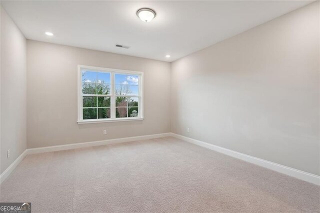 carpeted spare room featuring recessed lighting, visible vents, and baseboards