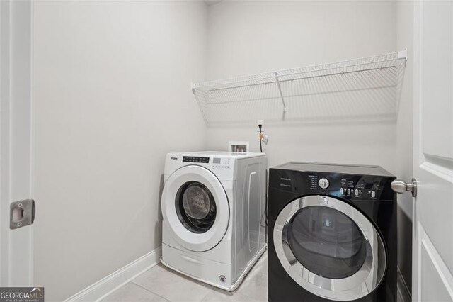 washroom featuring laundry area, light tile patterned floors, baseboards, and independent washer and dryer