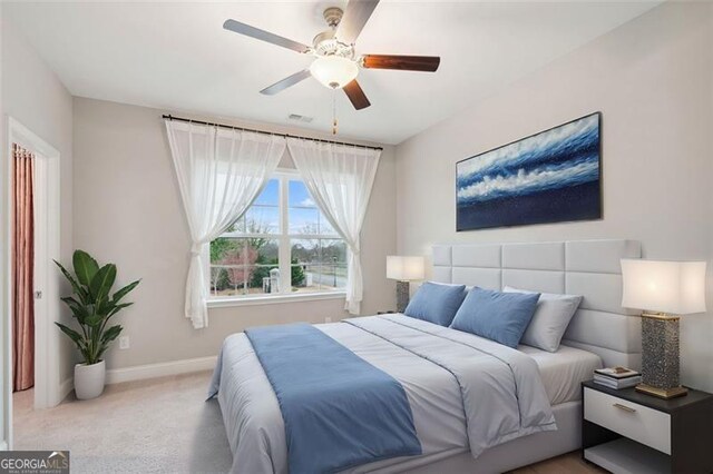 carpeted bedroom with ceiling fan and baseboards