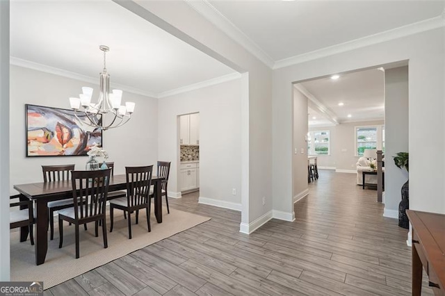 dining space featuring recessed lighting, crown molding, baseboards, light wood finished floors, and an inviting chandelier