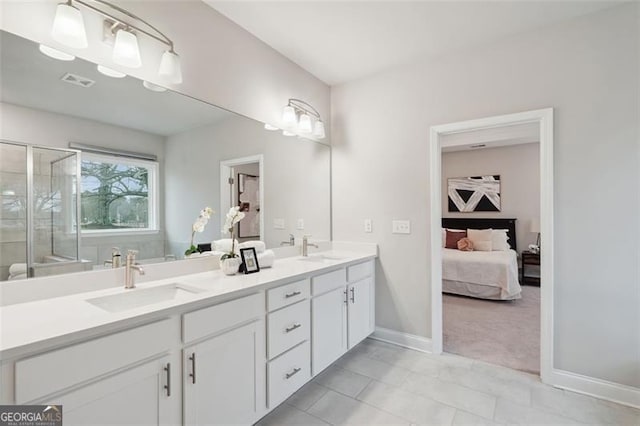 ensuite bathroom with double vanity, a stall shower, visible vents, and a sink