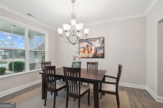 dining area with baseboards, visible vents, ornamental molding, dark wood-type flooring, and a chandelier