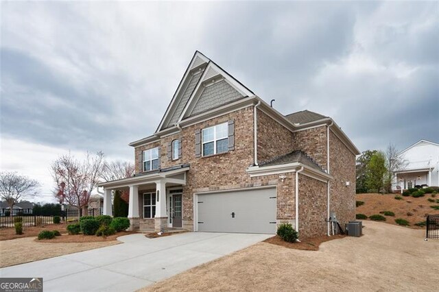 craftsman-style home featuring brick siding, driveway, an attached garage, and fence