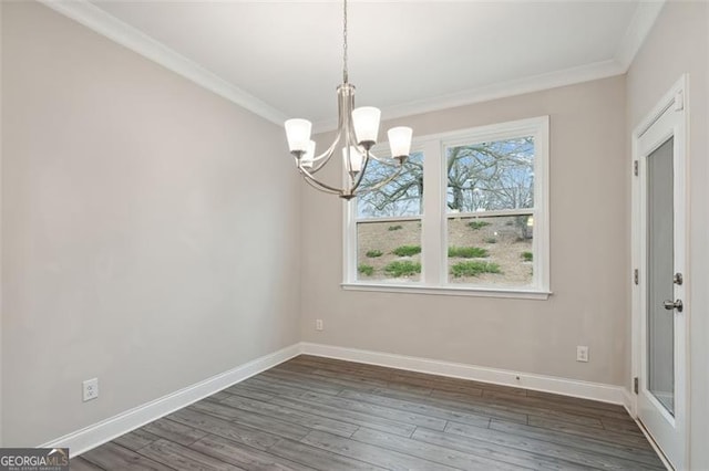 unfurnished dining area with an inviting chandelier, baseboards, ornamental molding, and dark wood-style flooring