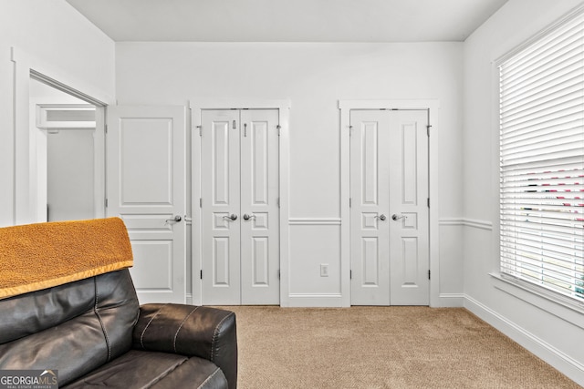 sitting room with light colored carpet, baseboards, and a wealth of natural light