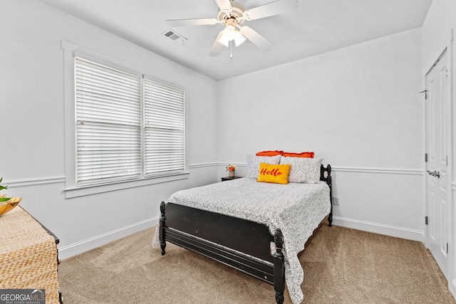 carpeted bedroom with a ceiling fan, baseboards, and visible vents