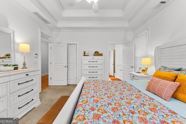 bedroom featuring a tray ceiling, crown molding, and visible vents