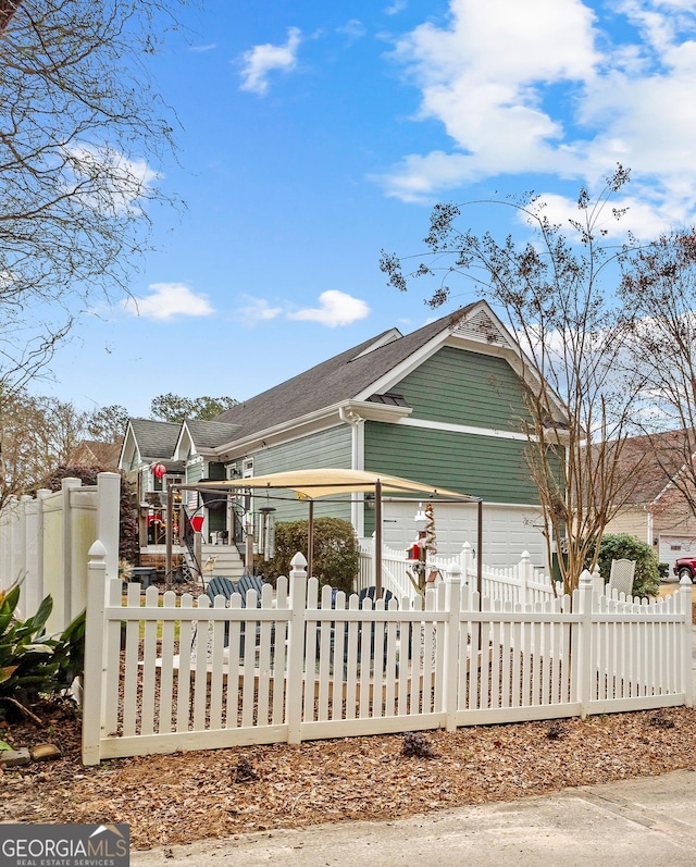 view of property exterior with an attached garage and a fenced front yard