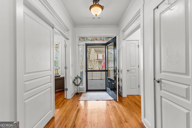 entryway featuring visible vents, light wood-type flooring, crown molding, and baseboards