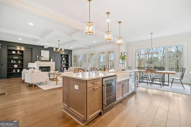 310 Timberview Trl, Alpharetta, GA 30004 - kitchen featuring beverage cooler, light countertops, a sink, light wood-type flooring, and crown molding
