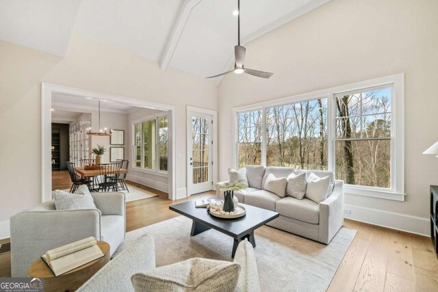 sunroom / solarium with vaulted ceiling with beams and ceiling fan with notable chandelier