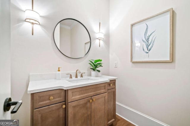 bathroom featuring vanity, baseboards, and wood finished floors