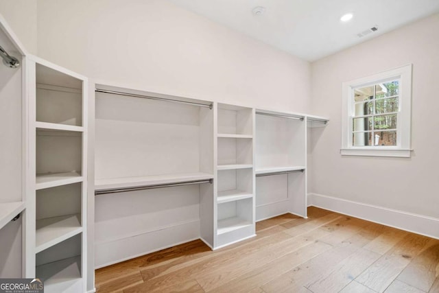 spacious closet featuring visible vents and wood finished floors