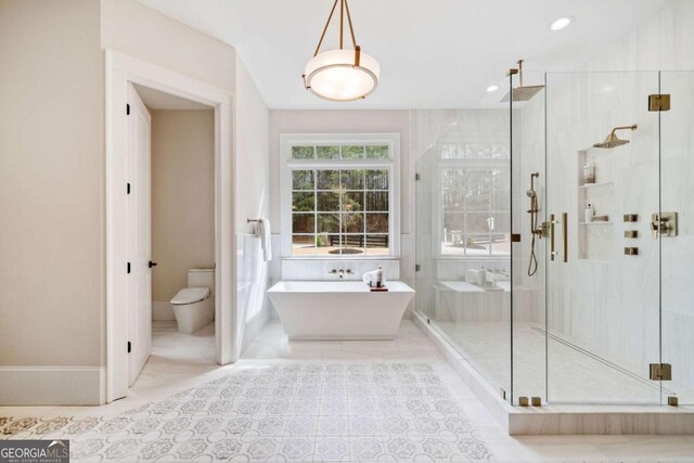 full bathroom with a stall shower, a freestanding tub, toilet, and recessed lighting